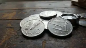 Monete da 10 lire con la spiga su un tavolo in legno, con lente d’ingrandimento per la valutazione numismatica